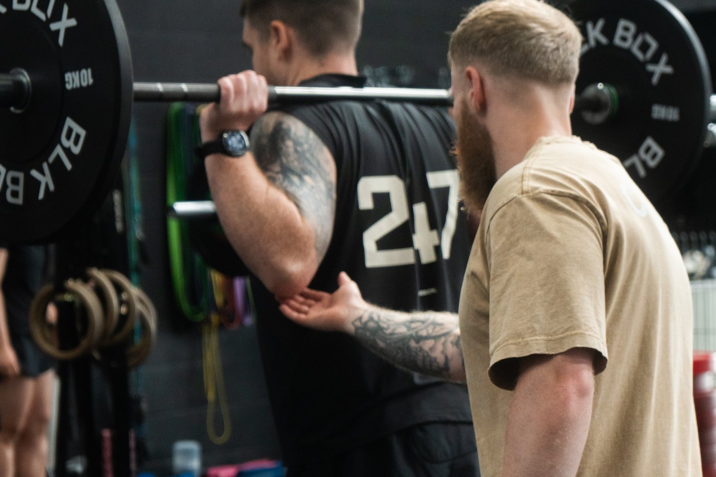 Coach Ben guiding a G45 member through a back squat